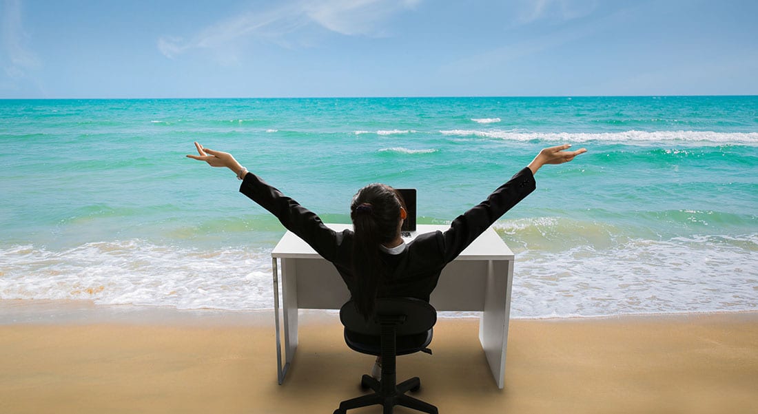 Woman sitting at office desk on the beach